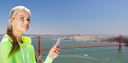 Image showing sportswoman listening to music over san francisco