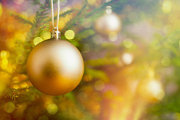 Image showing Christmas-tree decoration bauble on decorated Christmas tree bac