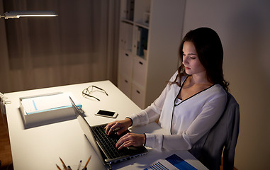 Image showing businesswoman with laptop at night office