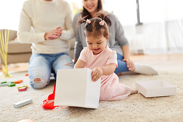 Image showing baby girl with birthday gift and parents at home