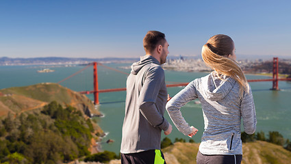 Image showing happy couple running over golden gate bridge