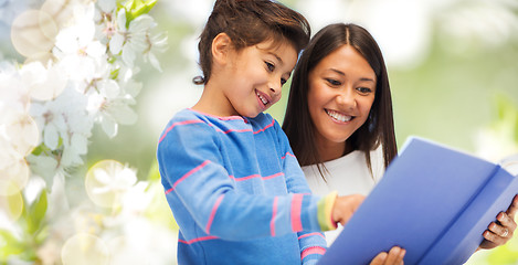 Image showing happy mother and daughter reading book