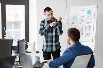 Image showing man showing smart watch to creative team at office