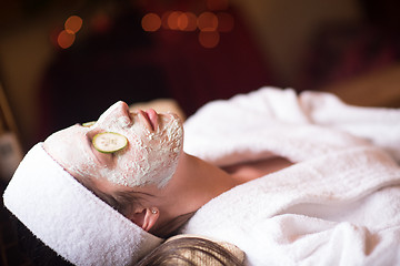 Image showing woman is getting facial clay mask at spa