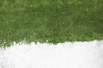 Image showing Meeting snow on green grass close up - between winter and spring concept background