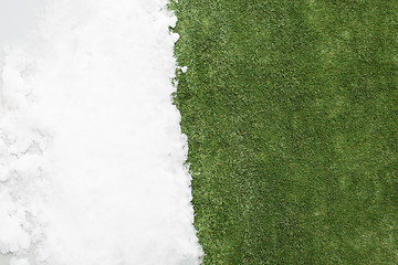 Image showing Meeting snow on green grass close up - between winter and spring concept background