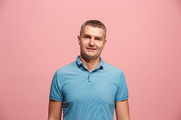 Image showing The happy business man standing and smiling against pink background.