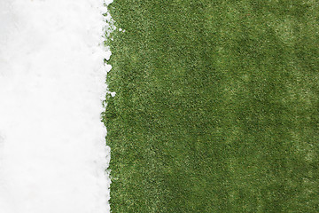 Image showing Meeting snow on green grass close up - between winter and spring concept background