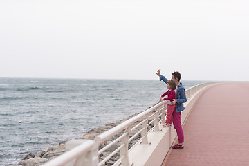 Image showing mother and cute little girl on the promenade by the sea