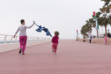 Image showing mother and cute little girl on the promenade by the sea