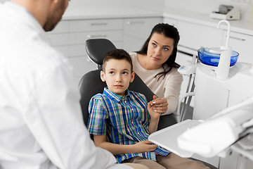 Image showing mother and son visiting dentist at dental clinic