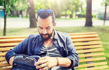 Image showing man with backpack and earphones in city