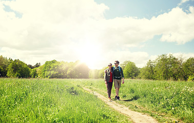 Image showing happy couple with backpacks hiking outdoors