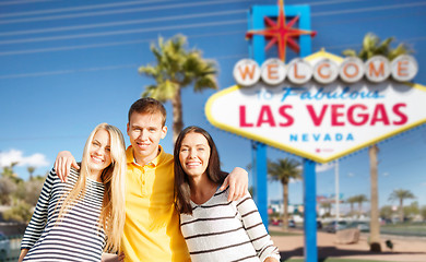 Image showing happy friends over welcome to las vegas sign