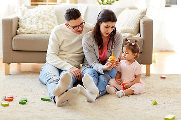 Image showing baby girl with parents at home birthday party