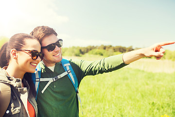 Image showing happy couple with backpacks hiking outdoors