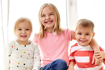 Image showing happy little kids hugging at window