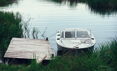 Image showing Motorboat At The Pier Among The reeds In A River Bay