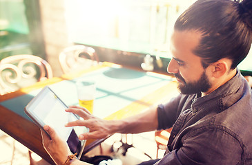 Image showing man with tablet pc drinking beer at bar or pub