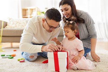 Image showing baby girl with birthday gift and parents at home