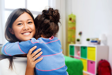 Image showing happy mother and daughter hugging at home