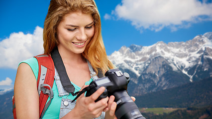 Image showing woman with backpack and camera over alps mountains