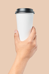 Image showing Mockup of men\'s hand holding white paper large size cup with black cover