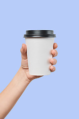 Image showing Mockup of men\'s hand holding white paper mid size cup with black cover