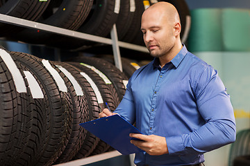 Image showing auto business owner and wheel tires at car service