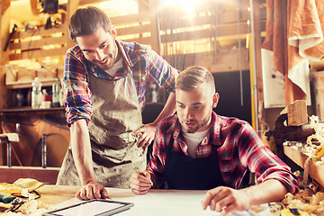 Image showing workmen with tablet pc and blueprint at workshop