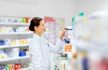 Image showing happy female apothecary with drug at pharmacy