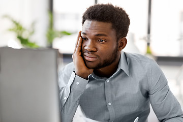 Image showing stressed businessman with computer at office