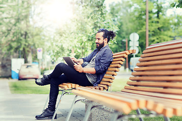 Image showing man with tablet pc sitting on city street bench