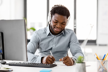 Image showing businessman with headphones and papers at office