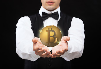 Image showing close up of magician with bitcoin over black