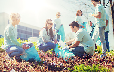 Image showing volunteers with garbage bags cleaning park area