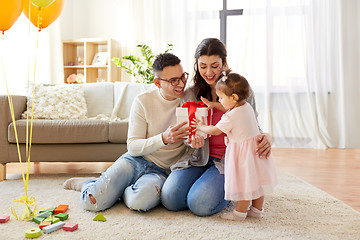 Image showing baby girl with birthday gift and parents at home