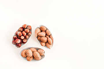 Image showing Plates with almonds, hazelnuts and walnuts