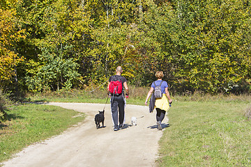 Image showing Young couple are hiking through the forest with their pet dogs