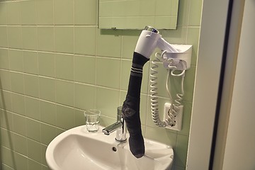 Image showing Drying sock in a hairdryer