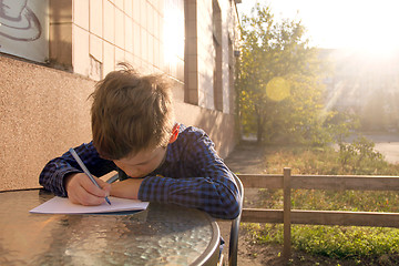 Image showing Boy doing homework outdoors