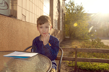 Image showing Boy doing homework outdoors