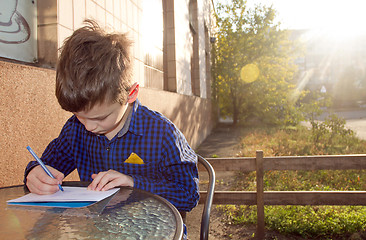 Image showing Boy doing homework outdoors