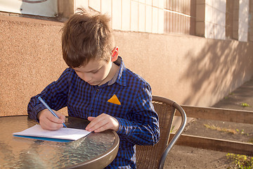 Image showing Boy doing homework outdoors