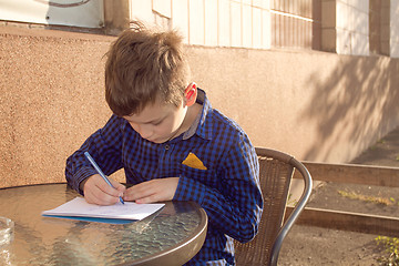 Image showing Boy doing homework outdoors