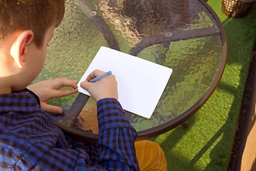 Image showing Boy doing homework outdoors