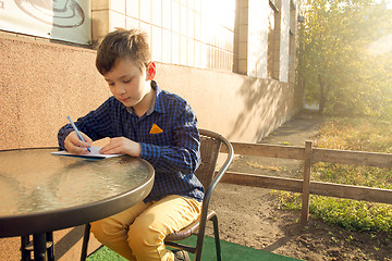 Image showing Boy doing homework outdoors