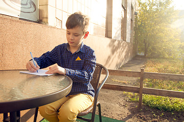 Image showing Boy doing homework outdoors