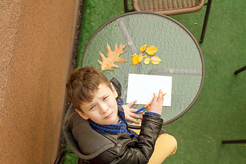 Image showing Boy is doing homework outdoors