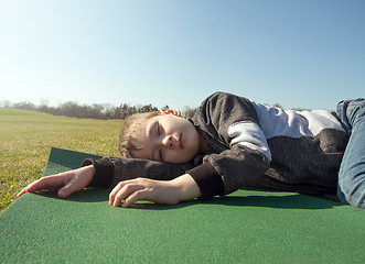 Image showing Boy sleep outdoors in the autumn park